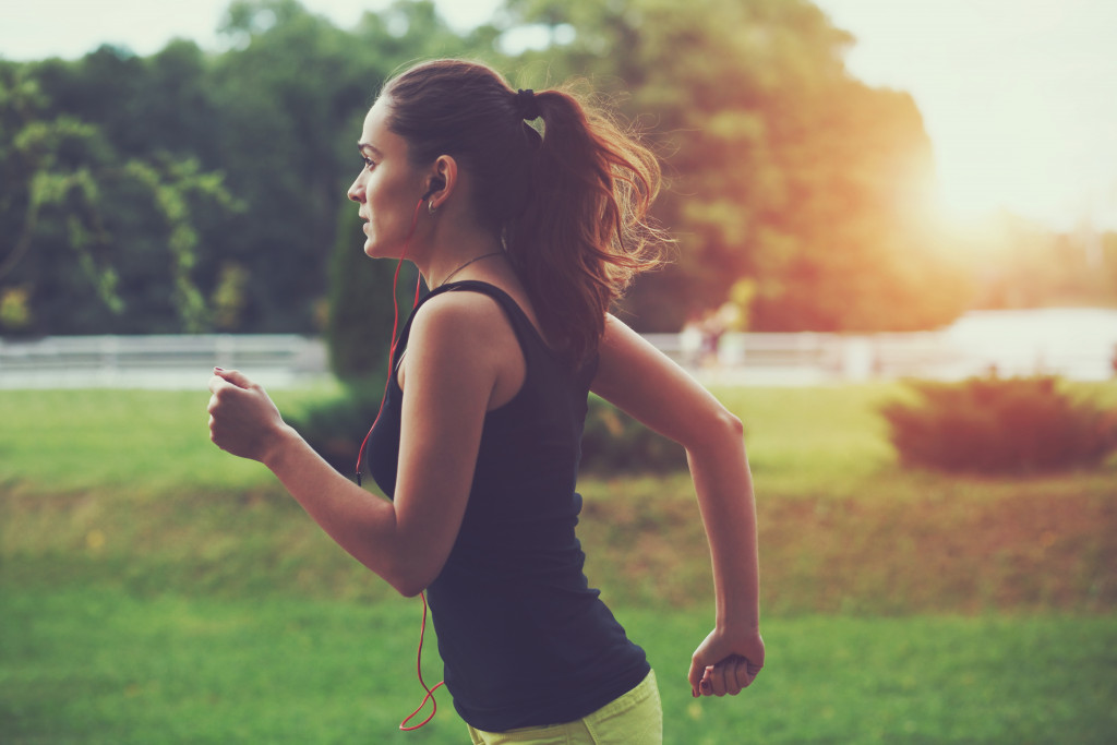 woman jogging at park in sunrise light